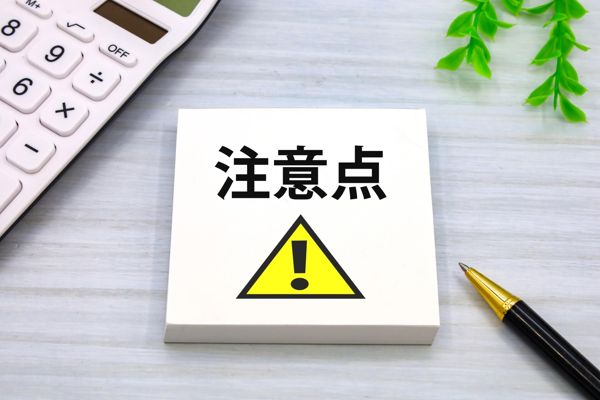 警告サインとペンと電卓の組み合わせ