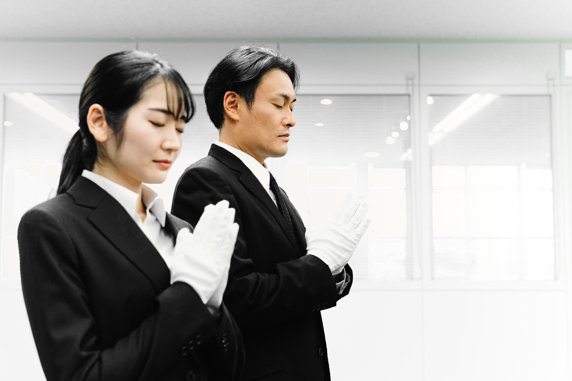 白い手袋をつけた男女の姿